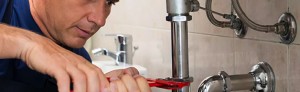 A person is using a pair of scissors to cut the faucet.