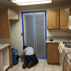 A man is painting the kitchen door.